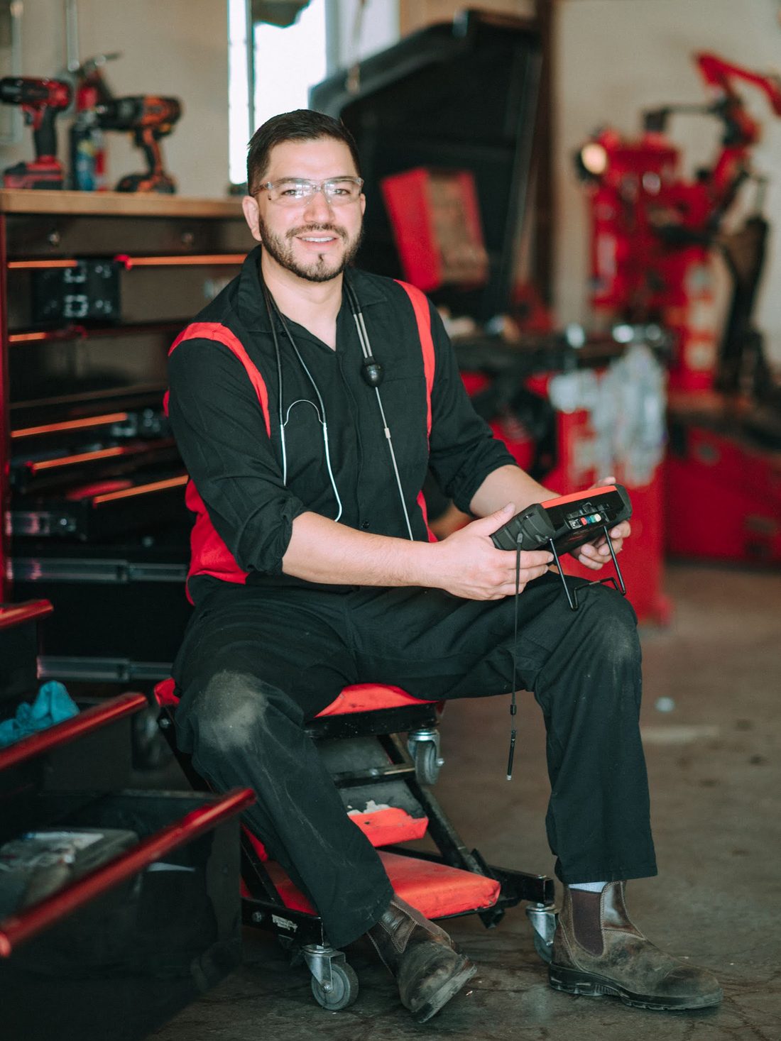 Rafael Mu&ntilde;oz seated beside his tool chest at Rafa&rsquo;s Auto Repair, scan tool in hand