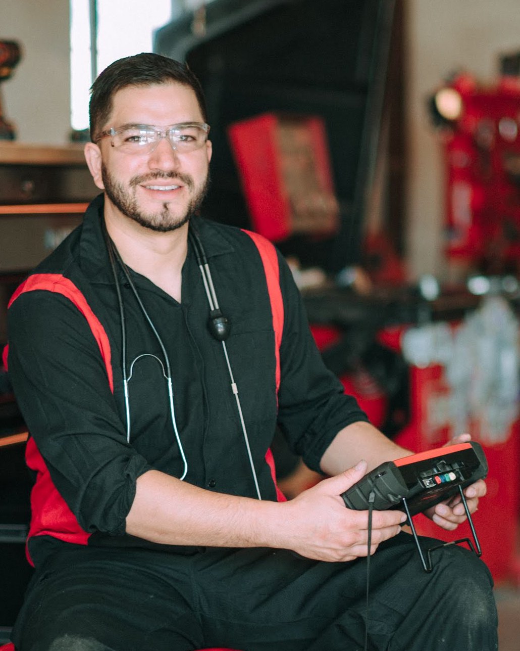 Rafael Mu&ntilde;oz, owner of Rafa&rsquo;s Auto Repair, holding a diagnostic scan tool in his shop in Santa Fe